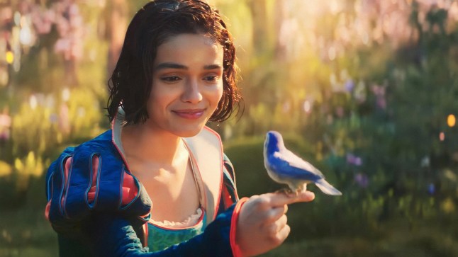 Rachel Zegler as Snow White in the live action remake of Snow White. She is holding a bird in her hand