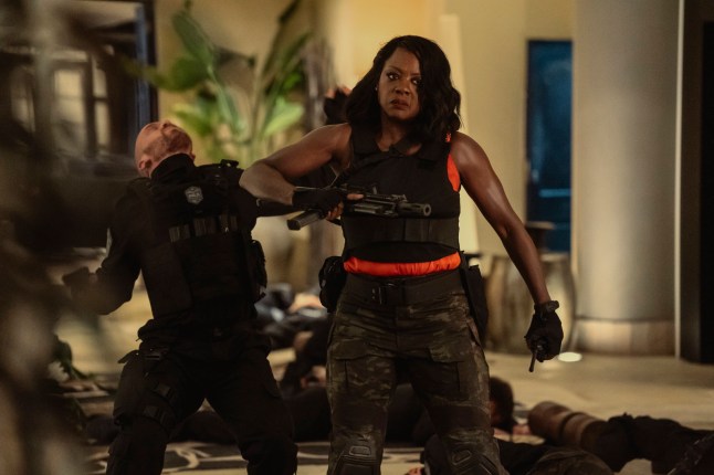 Viola Davis as President Danielle Sutton in combat trousers and a bulletproof vest. She is holding a gun and calmly delivering an elbow to the neck of a guy behind her in G20