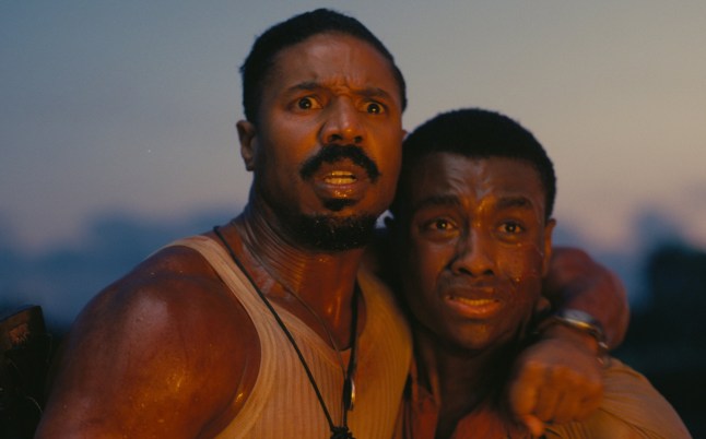 Michael B Jordan as Smoke and Miles Caton as Sammie in Sinners. They have their arms around each other and appear scared