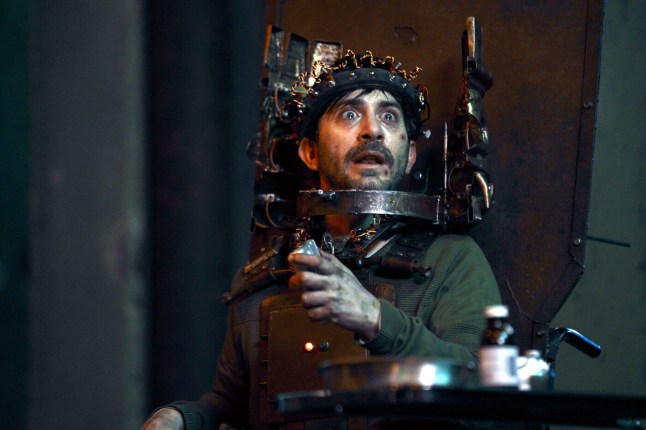 Octavio Hinojosa as Mateo in Saw X appearing scared in one of Jigsaw's traps