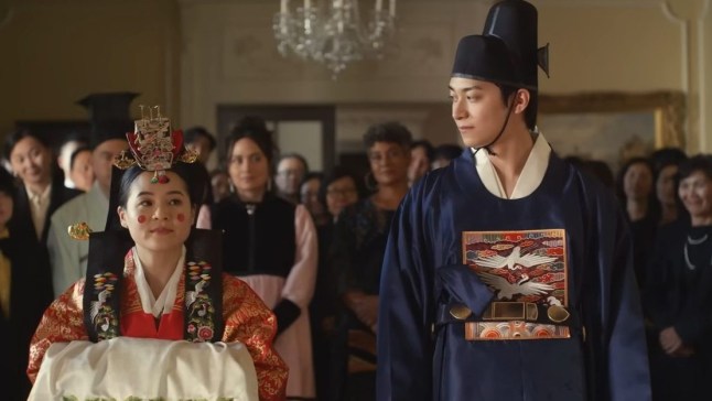 A still from The Wedding Banquet of a man and a woman in traditional Korean clothing at a wedding ceremony